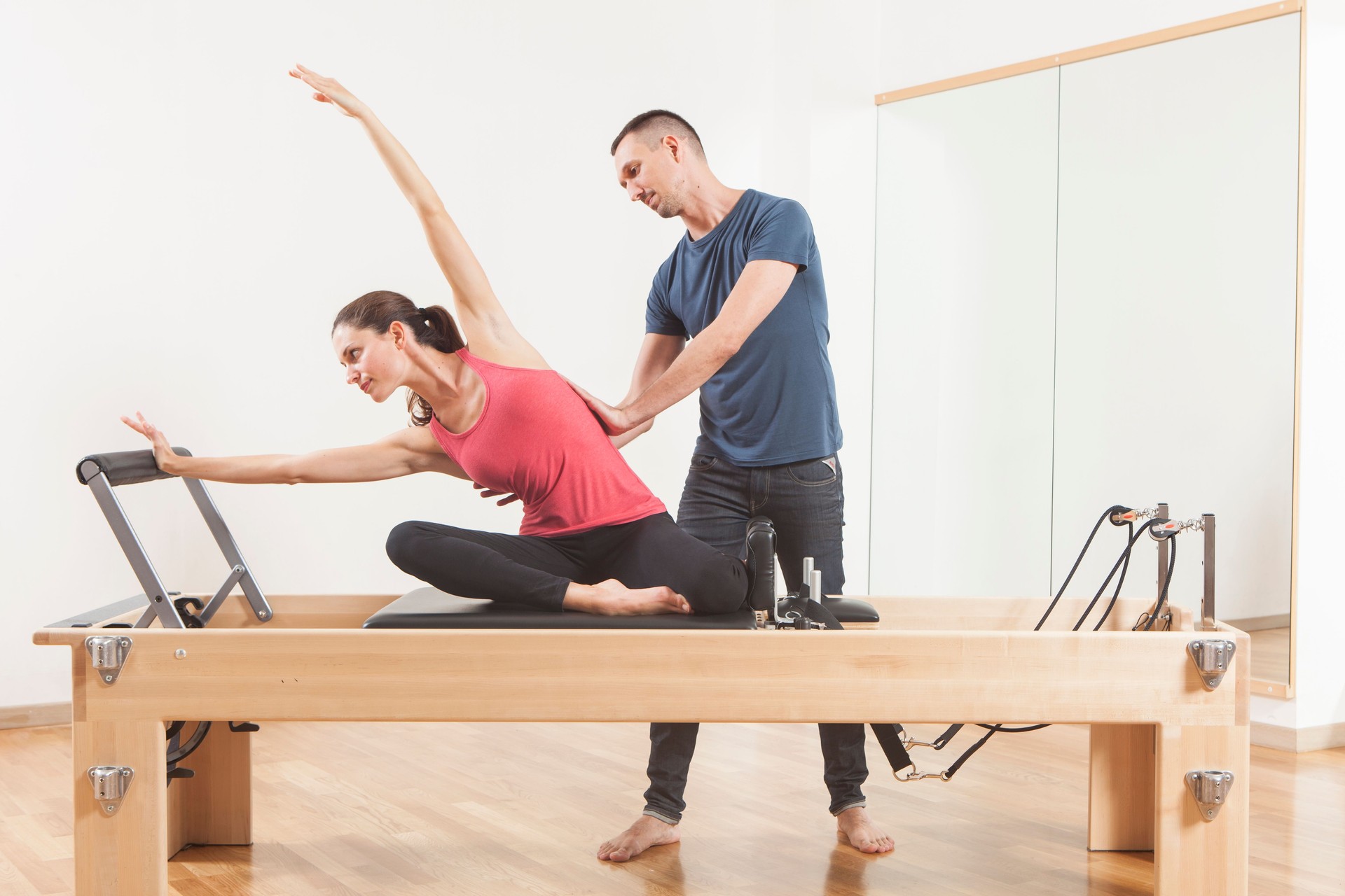 Pilates lesson on reformer, personal coaching young beautiful woman