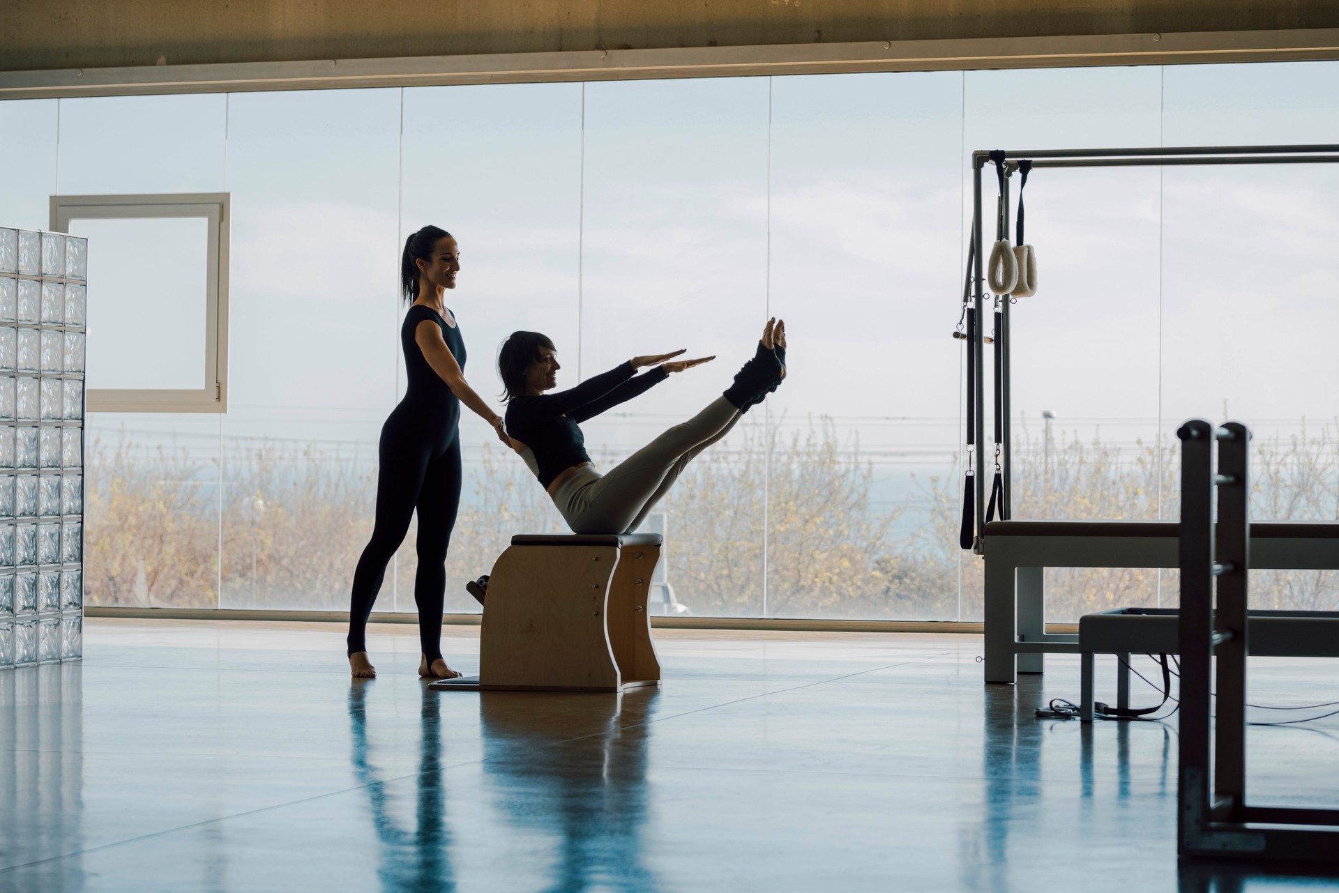 Personal trainer correcting posture, helping the client with exercises.